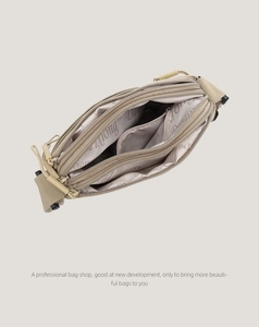 Top view showing the three-layer zipper compartments of this beige nylon crossbody bag