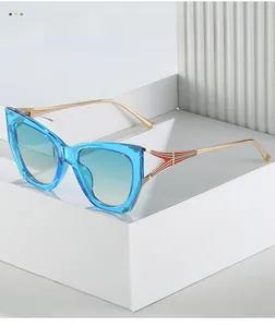 Macro view of blue cat eye sunglasses featuring gold metal temples with red and green stripes