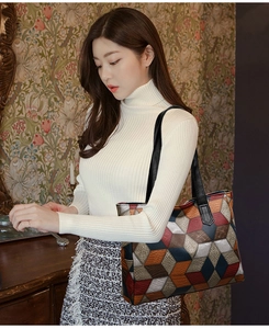 Dettaglio di una borsa tote grande con motivo geometrico 3D patchwork indossata da modella
