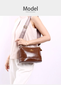 Detailed view of brown leather bag with parallel embossing and golden kangaroo logo
