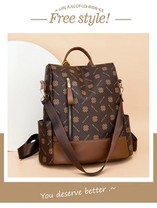 Detail view of large brown vintage backpack with clover pattern and front zipper pocket