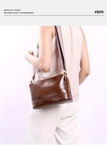 Detail of dark brown embossed shoulder bag with colorful geometric jacquard strap