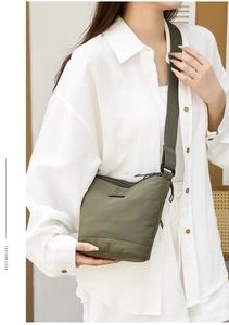 Crossbody nylon bucket bag detail showing adjustable wide strap and smooth army green texture