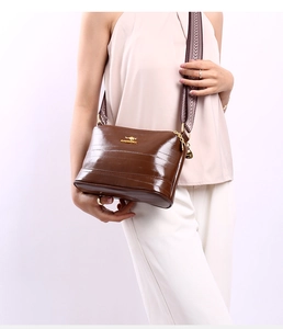 Women's brown faux crocodile leather bag with wide woven strap and golden logo