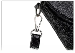 Detailed close-up of silver metal lobster clasp and black pebble leather strap