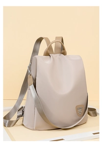 Close-up of beige waterproof Oxford backpack featuring premium silver hardware and logo