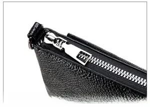Close-up of premium silver zipper and hardware on black litchi grain leather bag