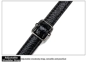 Detail of adjustable black lychee leather strap with polished metal buckle for handbags
