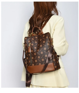 Detail of vintage brown patterned backpack featuring multiple pockets and high-quality PU leather