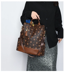 Detail of vintage brown clover monogram backpack with gold hardware and leather handle