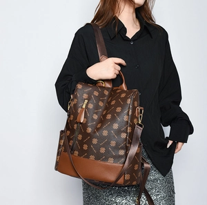 Fashionable brown backpack with clover print shown on a model with a black shirt