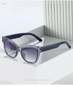 Dettaglio degli occhiali da sole cat-eye viola traslucidi su un supporto bianco minimalista