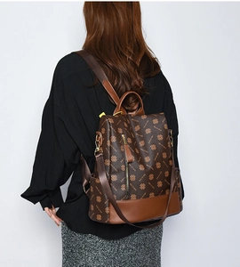 Detailed back view of vintage monogram brown leather backpack with adjustable straps