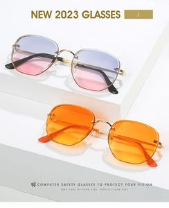 Close-up of geometric sunglasses in gradient pink and orange with gold metal frames