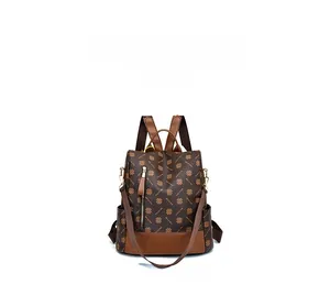 Front detail of brown vintage backpack featuring clover pattern and vertical zipper pocket