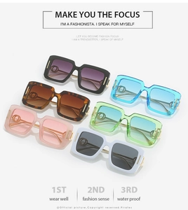 Detail of square sunglasses with golden interlocking ring accents and colorful frames