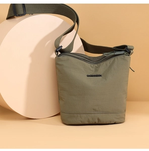 Detail view of military green nylon bucket bag with adjustable strap and logo