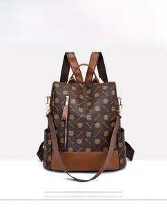 Front view of a brown vintage leather backpack with floral patterns and side pockets