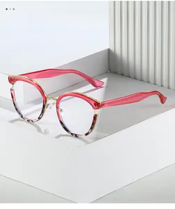 Detail of pink cat-eye frame with gold metal bridge and tortoiseshell texture accents