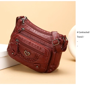 Dettaglio borsa a tracolla rosso vino con chiusura a cuore e tasche multiple con zip