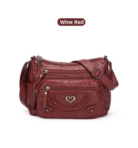 Dettaglio della borsa bordeaux con morbida trama litchi e tasche multiple con zip