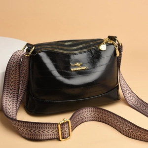 Women's glossy black crossbody bag with gold logo and colorful wide shoulder strap
