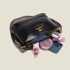 Women's black faux leather shoulder bag with wide strap and gold hardware accents