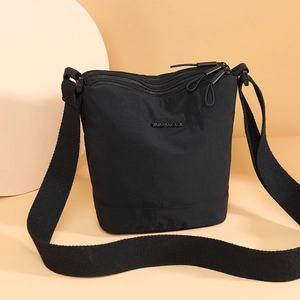 Fashionable black nylon bucket bag with multi-zipper design and wide shoulder strap