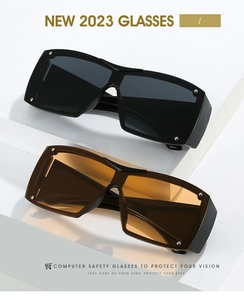Detail view of large Y2K visor sunglasses in black and brown with metal rivet accents