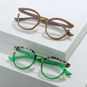 Modern metal cat eye glasses frames in coffee and green with gold trim on platforms