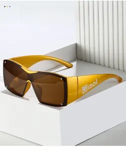 Detail of matte gold frame and integrated brown lenses on oversized Y2K sunglasses