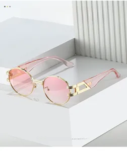 Détails de lunettes de soleil en métal doré avec verres roses et charnières décoratives