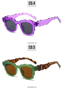Detail view of scalloped edge sunglasses in transparent purple and green tortoiseshell frames