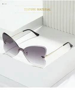Detail of rimless butterfly sunglasses with purple gradient lenses and gold metal temples
