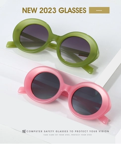 Detail of round sunglasses in lime green and pale pink frames on a white display stand