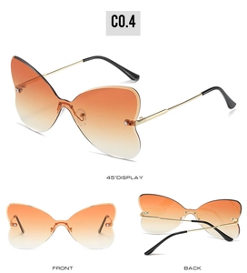 Detail view of rimless butterfly sunglasses with orange gradient lenses and gold metal frames