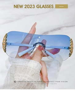 Detail of rimless Y2K sunglasses with gradient blue lenses and gold diamond accents