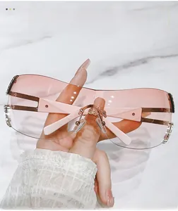 Detail of Y2K pink rimless shield sunglasses featuring hollow temples on marble background