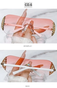 Detail view of Y2K rimless sunglasses with pink gradient lenses and rhinestone accents