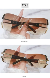 Detail of Y2K fashion sunglasses with rhinestone temples and brown gradient lenses