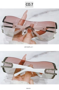 Detail view of pink gradient Y2K sunglasses with rhinestone-encrusted white temples