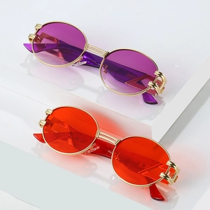 Lunettes de soleil ovales rétro en métal violet et orange sur des marches blanches
