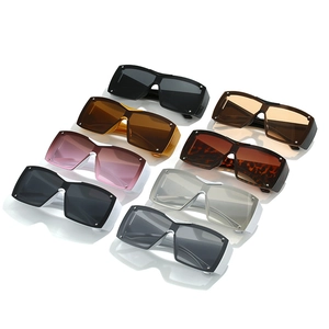 Eight pairs of Y2K shield sunglasses with large frames and rivets in diverse colors