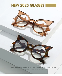 Detail view of oversized bat-shaped frames in tortoiseshell and transparent tea colors