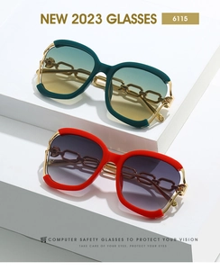 Détail de lunettes de soleil oversize avec branches en chaîne dorée sur décor