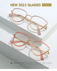 Close-up of stylish cat-eye glasses frames in pink and coral with slim gold metal temples