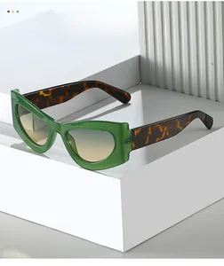 Détail de lunettes de soleil œil-de-chat vertes avec branches écaille et verres dégradés