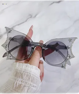 Detailed close-up of butterfly bat sunglasses featuring diamond-set frames and metal stars