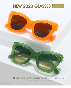 Détail de lunettes de soleil œil de chat tendance avec montures orange et vertes et points dorés