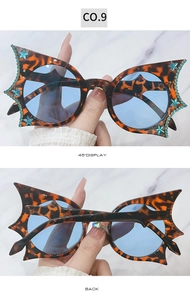 Detailed close-up of leopard print cat-eye frames with blue rhinestones and star accents